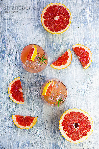 Gläser mit frischem Grapefruitsaft und Grapefruits