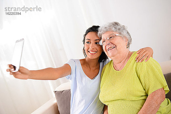 zwei Generation Frau jung und älter machen ein lustiges Selfie zusammen zu Hause