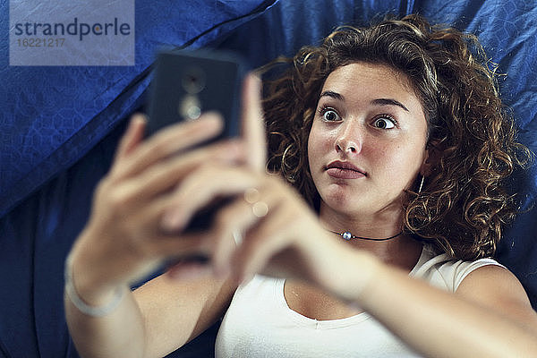 Mädchen im Teenageralter und Alltag. Im Bett mit Smartphone