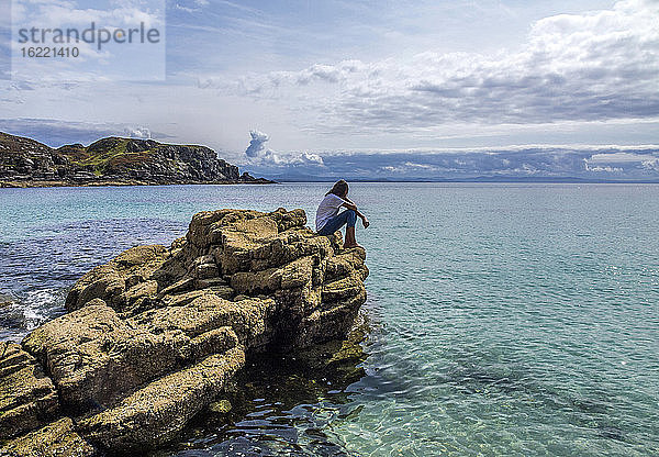 Europa  Großbritannien  Schottland  Hebriden  südöstlich der Isle of Skye  junger Tourist auf Felsen am Meer  Point of Sleat