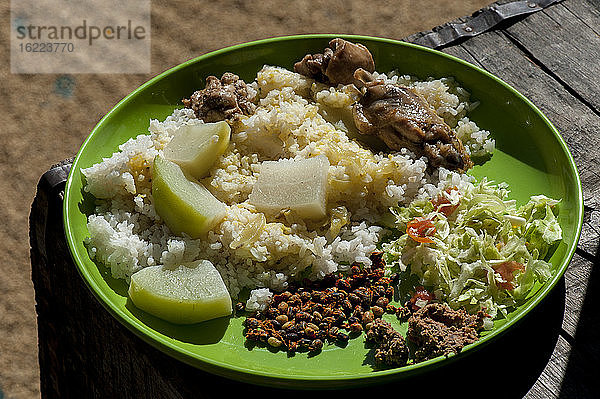 Einheimisches Gericht auf einem Teller mit getrocknetem Reis im Hintergrund  Khonoma  Nagaland  Indien