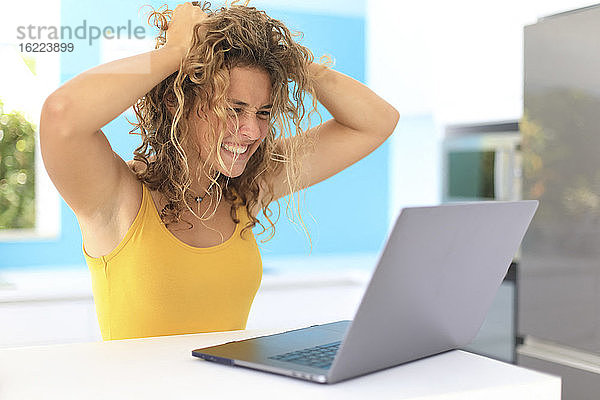 Junge Frau in ihrer Wohnung vor einem Laptop sitzend. Akquise