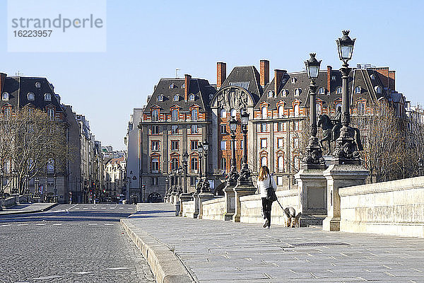 Frankreich  Paris (1. Arr.) 04/01/20. Eine alleinstehende Frau geht mit ihrem Hund auf dem leeren Pont-Neuf spazieren  nachdem die Bevölkerung zur Bekämpfung der Pandemie COVID-19 eingeschlossen wurde.