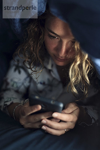 Teenager-Mädchen und Alltag. Im Bett mit Smartphone