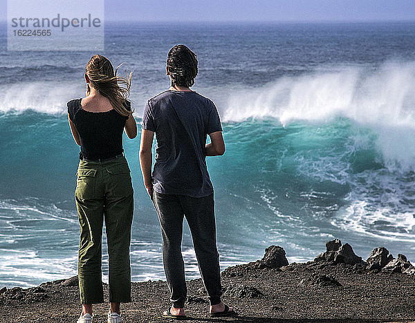 Spanien  Kanarische Inseln  Insel Lanzarote  El Golfo  Teenager fasziniert von den Wellen
