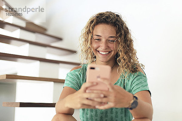 Junger Teenager zu Hause mit einem Smartphone. Selfie