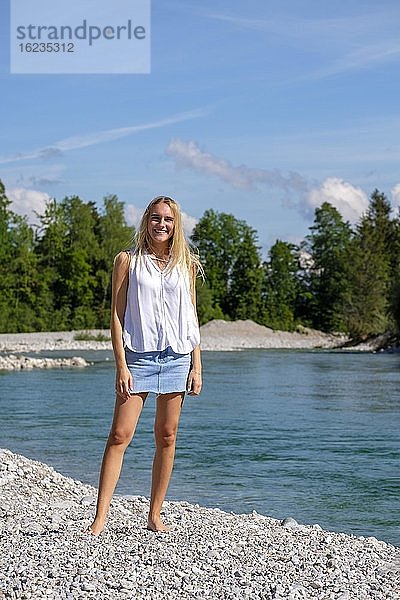 Porträt junge blonde Frau  Minirock  am Wasser  Sommer  Bayern  Deutschland  Europa