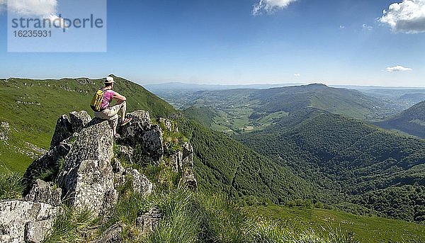 Wanderer mit Blick auf die Berge des Cantal  Regionaler Naturpark der Vulkane der Auvergne  Departement Cantal  Auvergne-Rhone-Alpes  Frankreich  Europa