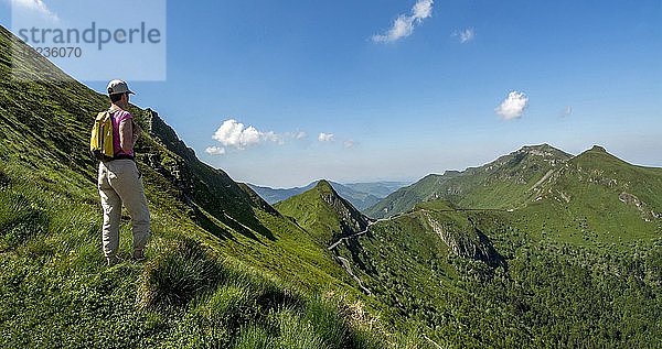 Wanderer mit Blick auf die Berge  Regionaler Naturpark der Vulkane der Auvergne  Departement Cantal  Auvergne-Rhone-Alpes  Frankreich  Europa