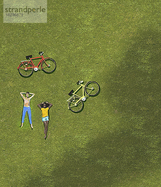 Draufsicht auf ein Paar  das sich auf einer Wiese neben Fahrrädern sonnt