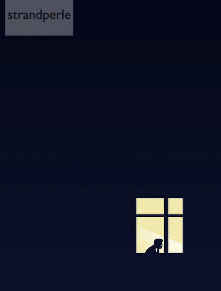 Einsame Figur in beleuchtetem Fenster