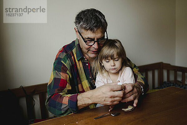 Großvater mit Enkelin am Tisch