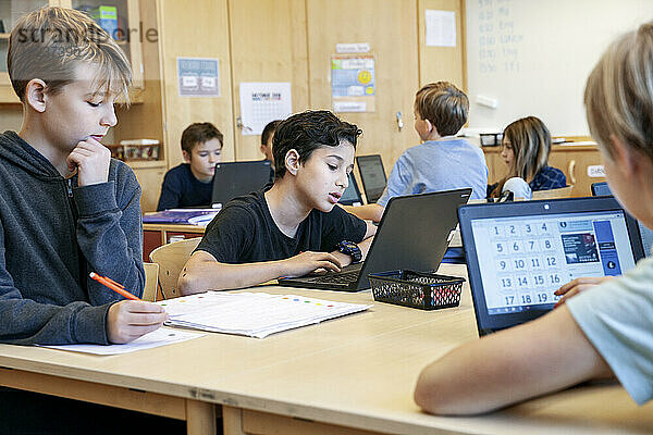 Jungen benutzen Laptops in der Schule