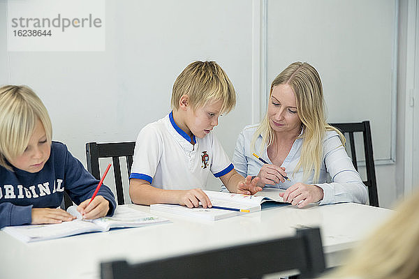 Lehrer hilft Jungen im Klassenzimmer