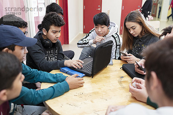 Teenager sitzen zusammen und benutzen einen Laptop