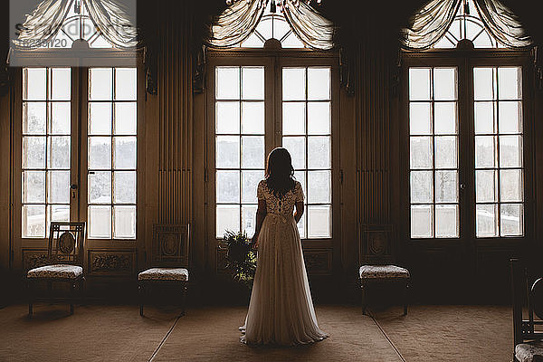 Braut schaut durch das Fenster