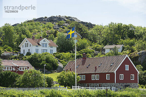 Schwedische Flagge vor einem Holzhaus
