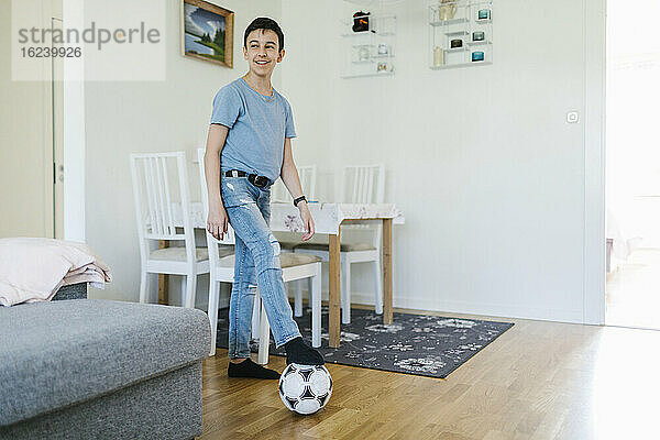 Junge mit Fußball zu Hause