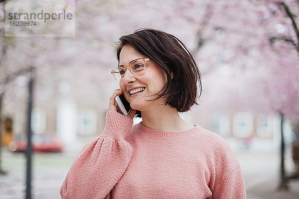 Lächelnde Frau  die über ein Mobiltelefon spricht