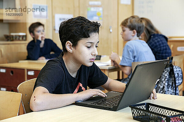 Junge benutzt Laptops in der Schule