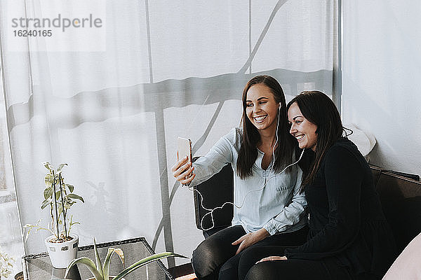 Mutter mit erwachsener Tochter macht Selfie