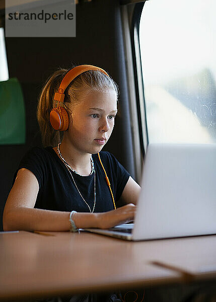 Mädchen im Zug mit Laptop