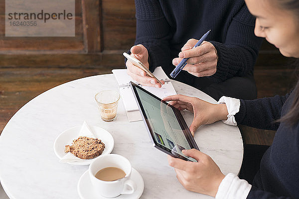 Paar in einem Café mit digitalen Geräten