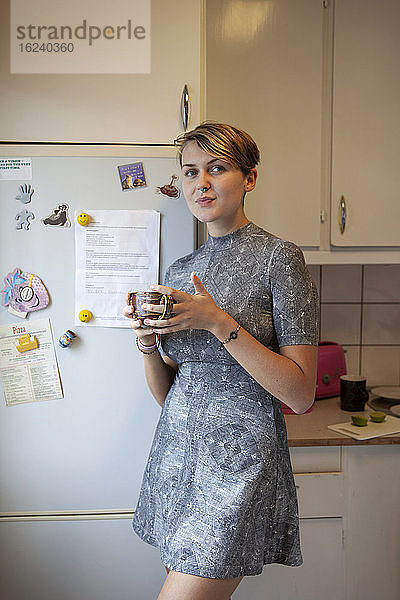 Frau trinkt Kaffee in der Küche