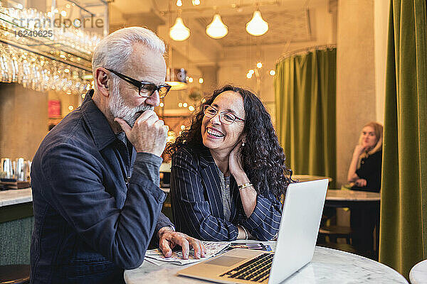 Älteres Paar benutzt Laptop in einem Cafe