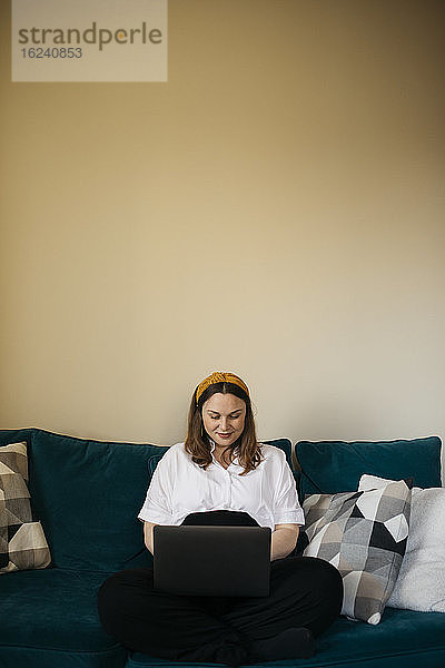 Frau auf Sofa mit Laptop