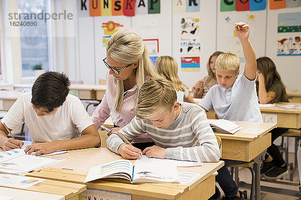 Lehrerin hilft Jungen im Klassenzimmer