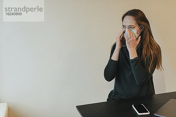 Frau mit Schutzmaske im Büro