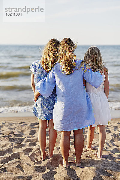 Mutter mit Töchtern am Strand