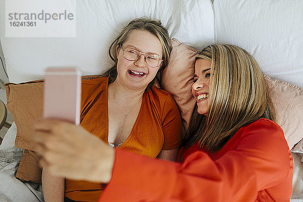 Schwestern auf dem Bett machen Selfie
