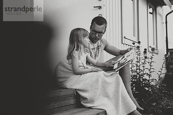Vater mit lesender Tochter