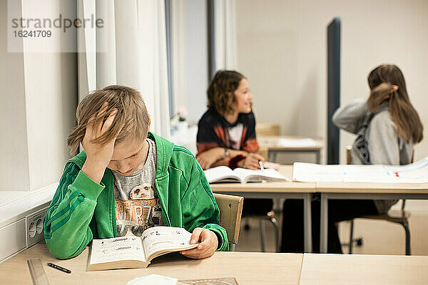Junge liest im Klassenzimmer