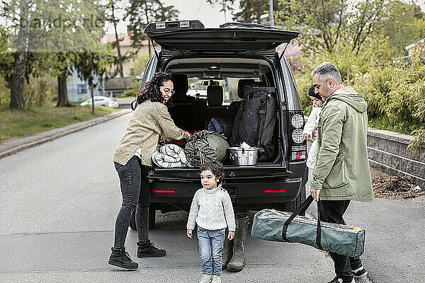 Eltern mit Kindern in der Nähe des Autos