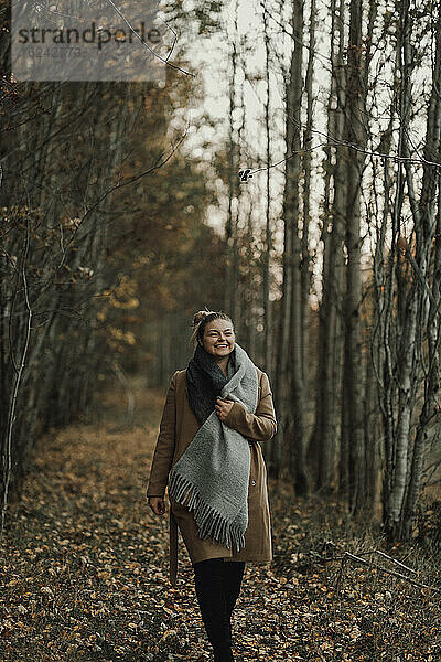 Frau geht durch Herbstwald