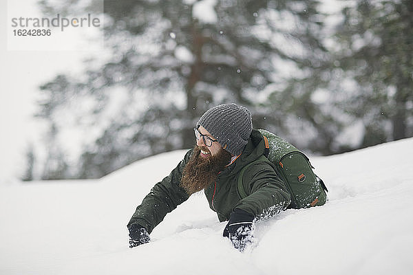 Mann spielt im Schnee