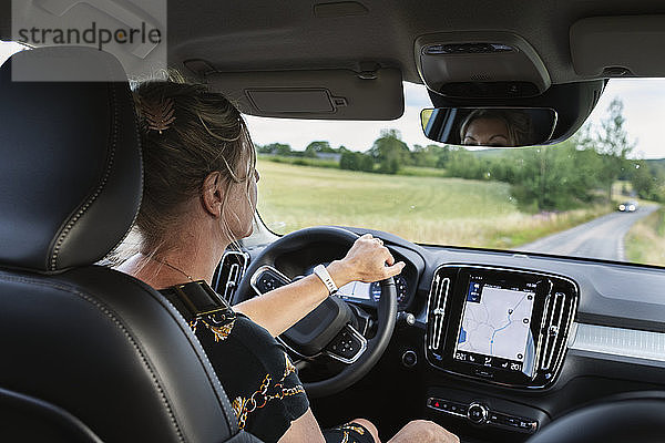 Frau fährt Auto mit GPS auf dem Armaturenbrett