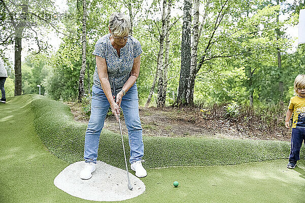 Frau spielt Minigolf