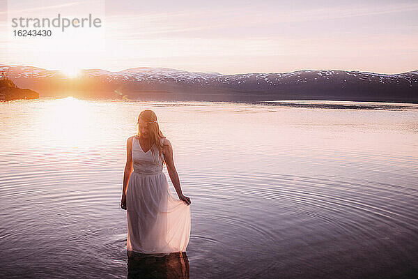 Frau im See bei Sonnenuntergang