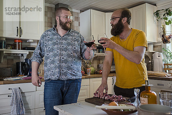 Männer in der Küche trinken Wein