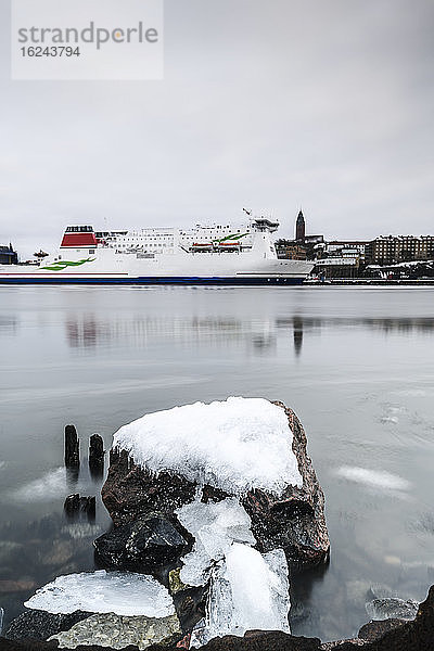 Schnee auf Felsen  Kreuzfahrtschiff im Hintergrund
