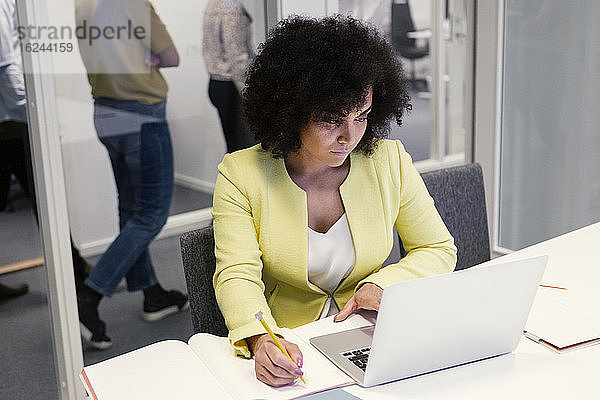 Frau benutzt Laptop im Sitzungssaal