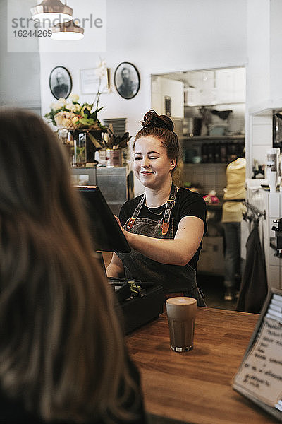 Lächelnde Frau bei der Arbeit im Cafe