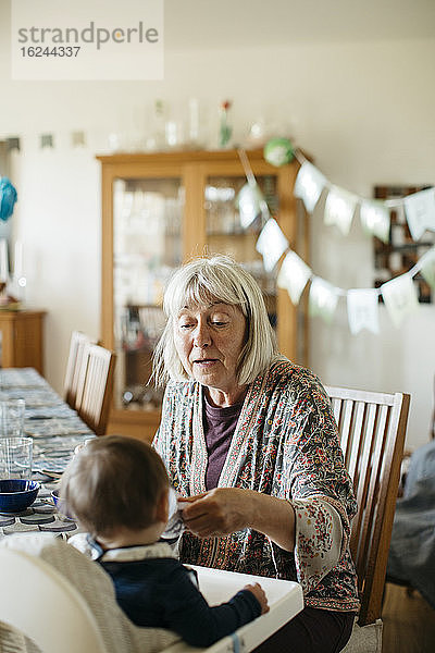 Großmutter füttert Enkelkind