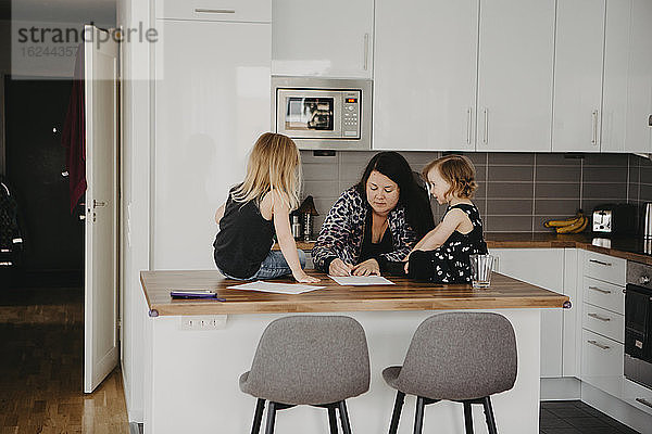 Frau mit zwei Töchtern in der Küche