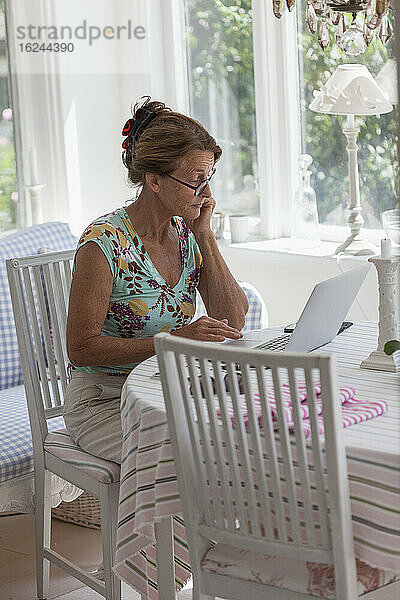 Frau benutzt Laptop zu Hause