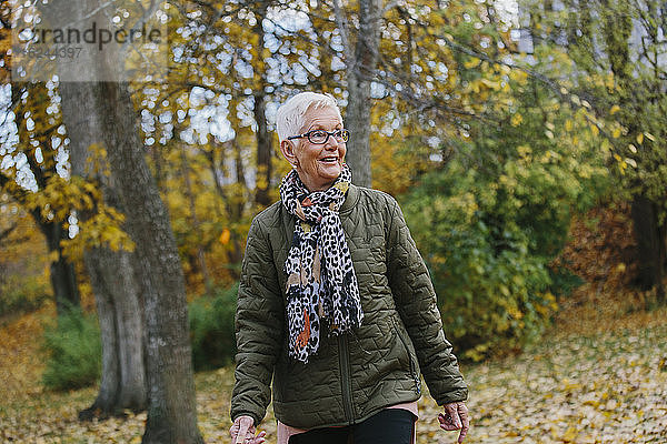 Ältere Frau beim Spaziergang im Herbst